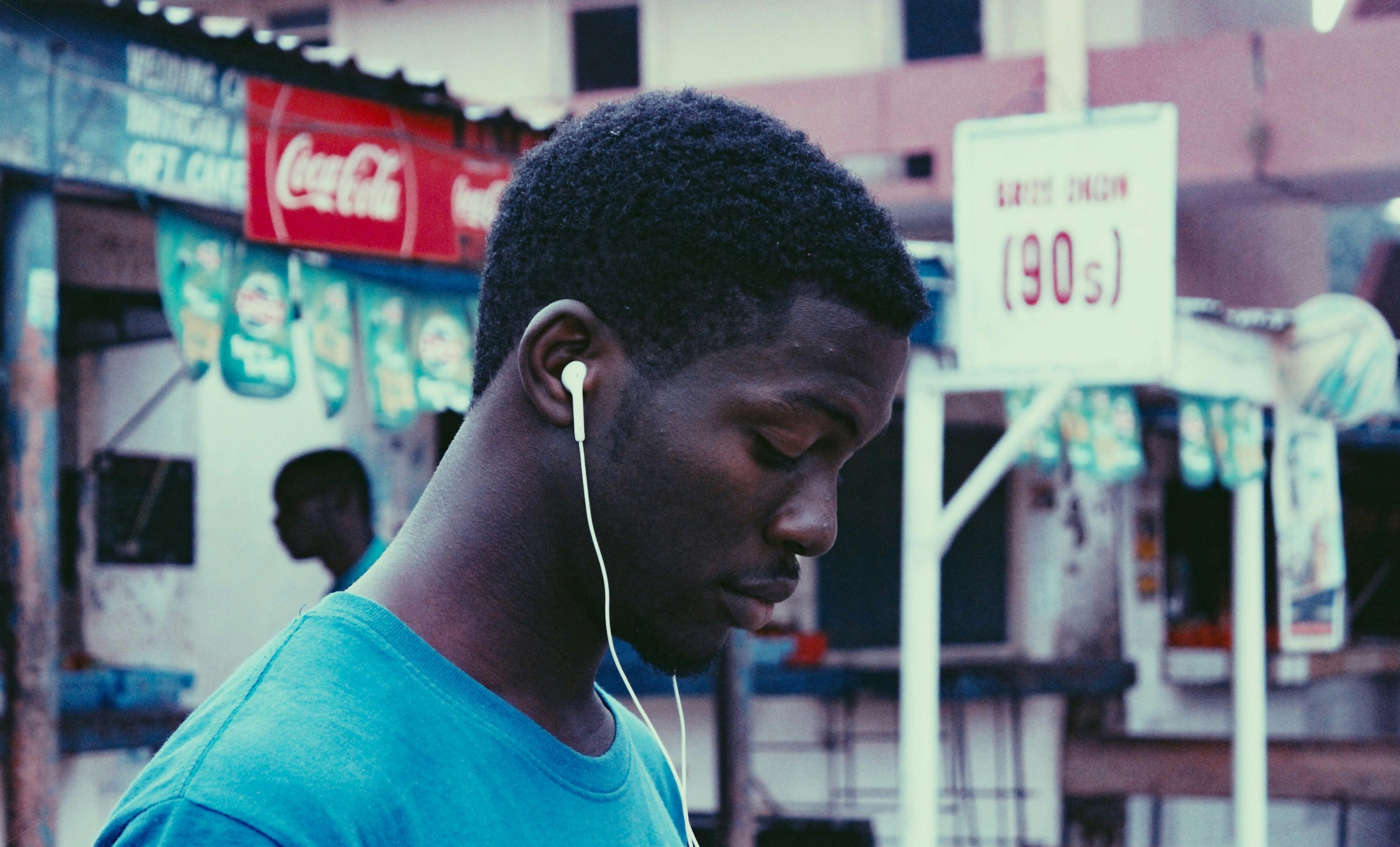 pexels-photo-2290243-2290243 Profile view of a young man wearing earphones on a bustling urban street.